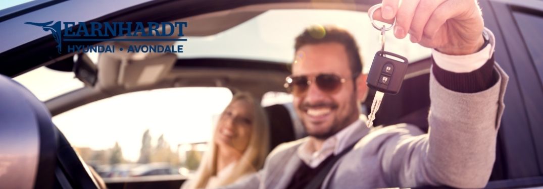 Happy Couple in New Car with Keys and Earnhardt Hyundai of Avondale Logo