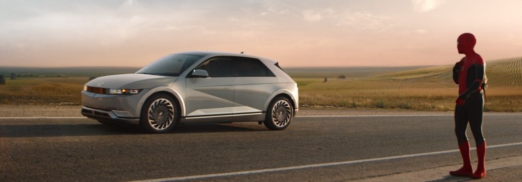 Spider-Man Walking on a Highway Next to a White 2022 Hyundai IONIQ 5