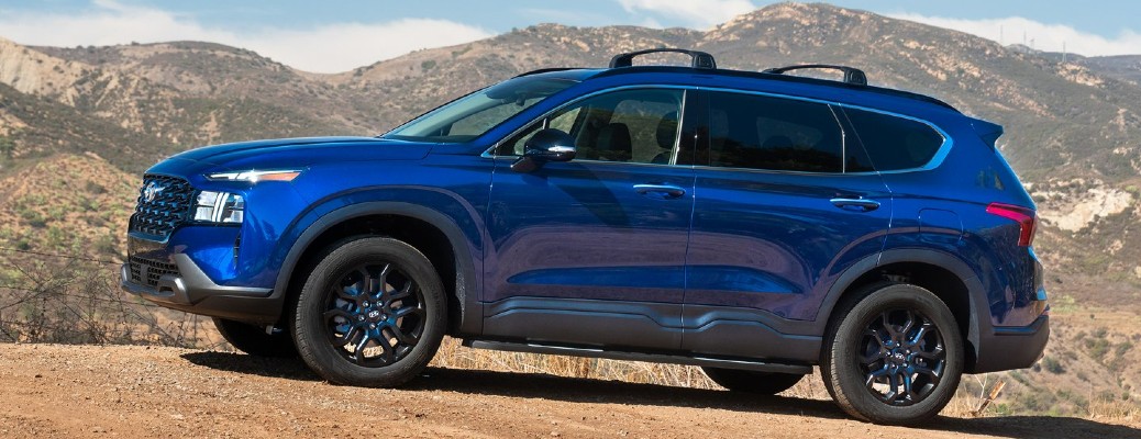 A blue 2022 Hyundai Santa Fe parked in a mountainous desert area.
