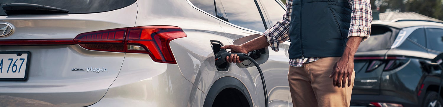 Cargo bed of a 2023 Hyundai Santa Fe Plug-In Hybrid SUV with a retractable tonneau cover.