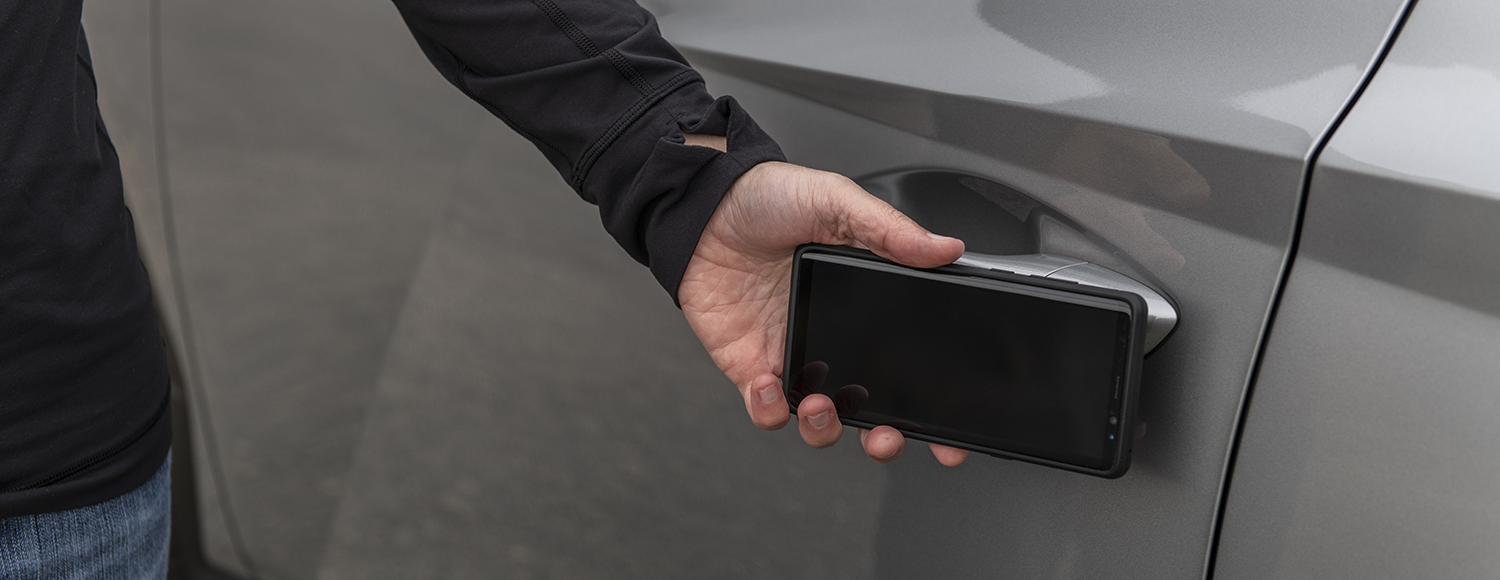 A smartphone being used as a key to unlock a 2023 Hyundai Tucson Hybrid
